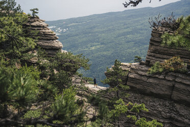 Entfernter kaukasischer Mann in Berglandschaft stehend - BLEF03134