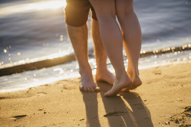 Legs of couple hugging at beach - BLEF03165