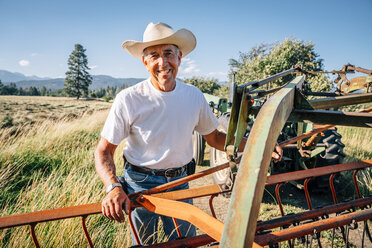 Portrait of Caucasian farmer standing near tractor - BLEF03206