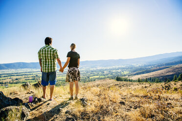 Caucasian couple standing on hill holding hands - BLEF03231