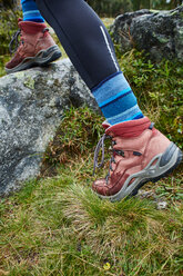 Female hiker stepping onto rock, close up of hiking boots - CUF51150