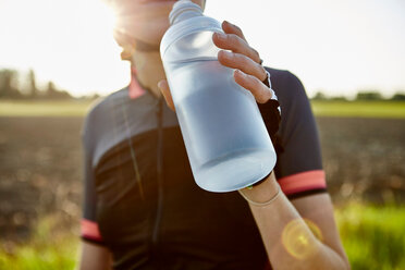 Radfahrerin trinkt aus Wasserflasche, beschnitten - CUF51158