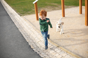 Boy running away from pet puppy - CUF51172