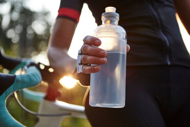 Radfahrerin hält Wasserflasche, Mittelteil - CUF51178