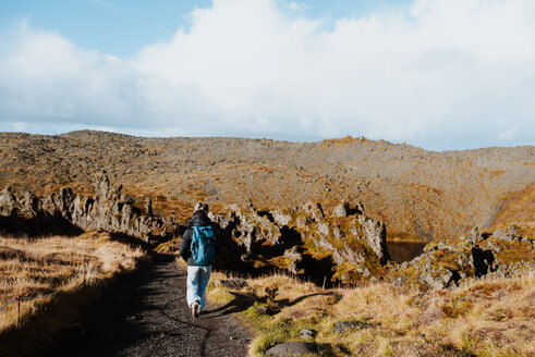 Tourist wandert auf einem Pfad zwischen Lavafelsen, Stykkishólmur, Snafellsnes- og Hnappadalssysla, Island - CUF51232
