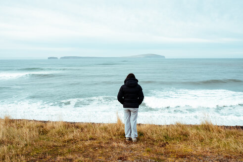 Tourist genießt Meerblick, Eskifjörður, Sudur-Mulasysla, Island - CUF51255