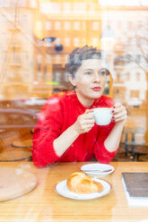 Mittlere erwachsene Frau im Café, Kaffee trinkend, Blick aus dem Fenster - CUF51267