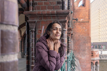 Woman leaning against railings of old building - CUF51274