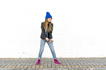 Smiling girl with smoke torch in front of white wall - ERRF01273