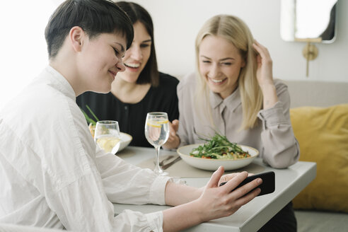 Glückliche Freunde mit Smartphone in einem Restaurant - AHSF00356