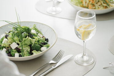 Salad and glass of water on a table in a restaurant - AHSF00358