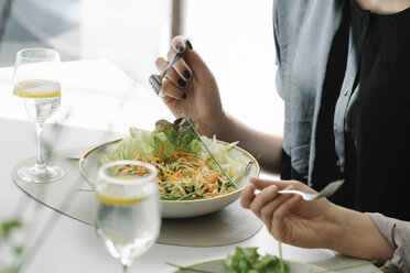 Nahaufnahme von zwei Frauen, die in einem Restaurant Salat essen - AHSF00360