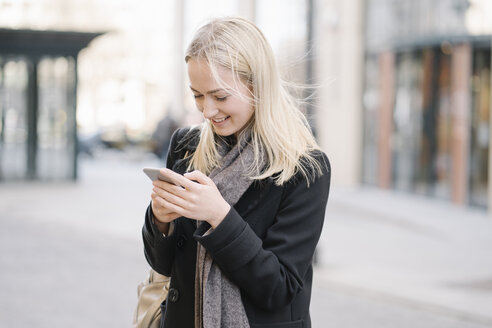 Junge Frau beim Telefonieren in der Stadt - AHSF00365