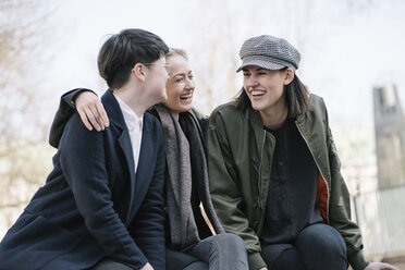 Gruppe glücklicher junger Frauen, die im Freien sitzen - AHSF00366