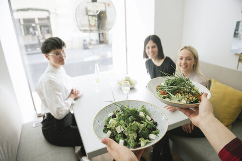 Kellner serviert Salat an Freunde in einem Restaurant - AHSF00376