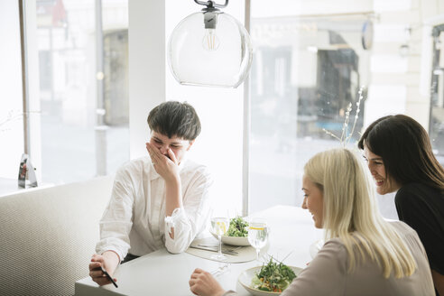 Glückliche Freunde mit Smartphone in einem Restaurant - AHSF00379