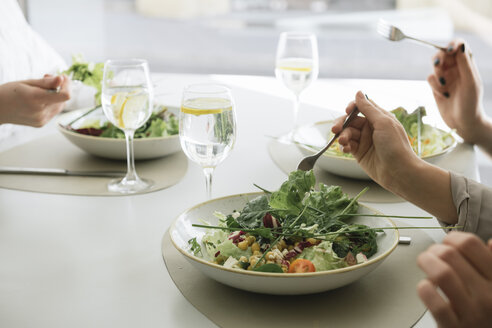 Nahaufnahme von drei Frauen, die in einem Restaurant Salat essen - AHSF00380