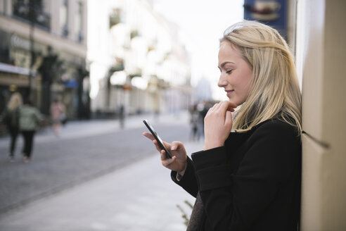 Junge Frau beim Telefonieren in der Stadt - AHSF00387