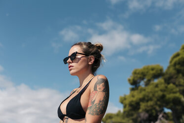 Spanien, Mallorca, Porträt einer tätowierten Frau mit schwarzem Bikini und Sonnenbrille - LOTF00071