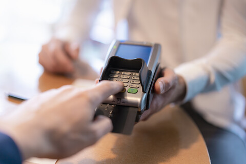 Mann mit Kreditkartenlesegerät, Nahaufnahme, lizenzfreies Stockfoto