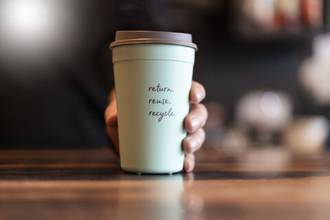 Hand hält Pfandbecher für Coffee to go, Nahaufnahme, lizenzfreies Stockfoto