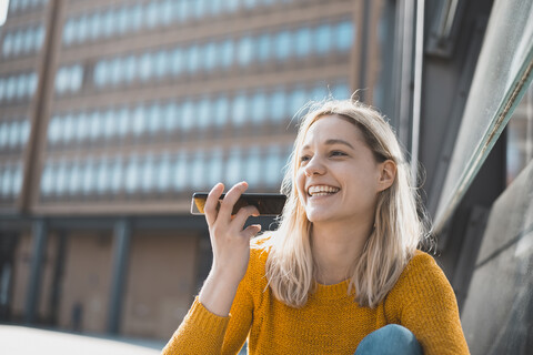 Porträt einer glücklichen jungen Frau am Telefon, lizenzfreies Stockfoto