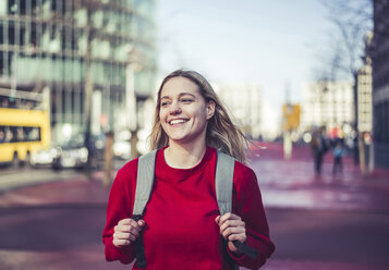 Germany, Berlin, portrait of laughing young woman with backpack in the city - BFRF02020
