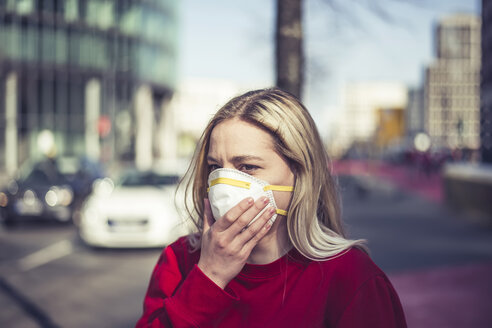 Deutschland, Berlin, Porträt einer jungen Frau mit Atemschutzmaske - BFRF02021