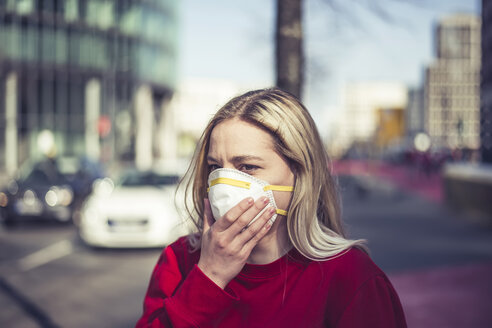 Germany, Berlin, portrait of young woman wearing pollution mask - BFRF02021