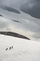 Russia, Kamchatka, Mutnovsky volcano, tourists crossing a snowfield - RUN01984