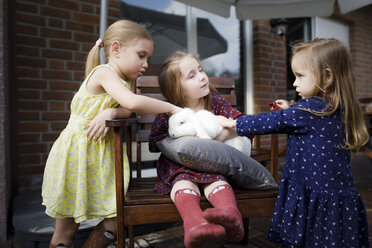 Drei Mädchen streicheln einen Hasen - KMKF00953