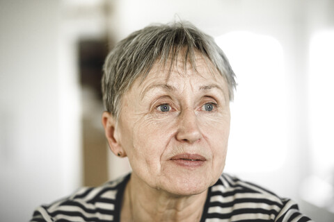 Porträt einer älteren Frau mit kurzen Haaren, die wegschaut, lizenzfreies Stockfoto