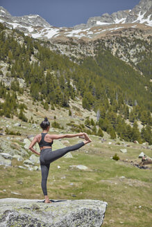 Junge Frau beim Yoga in der Natur, auf einem Bein stehend, Hasta Padangustasana - JPF00398