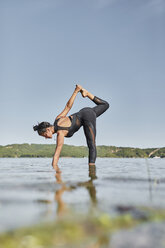 Junge Frau beim Yoga in der Natur - JPF00399