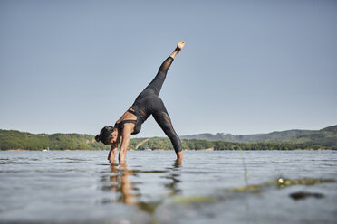 Junge Frau beim Yoga in der Natur, nach unten gerichtete Hundestellung - JPF00401