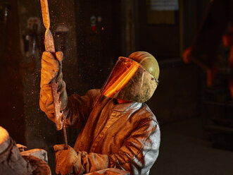 Industrie, Arbeiter am Schmelzofen beim Schmelzen von Kupfer, im Feuerschutzanzug - CVF01201