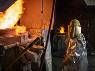 Industrie, Arbeiter am Schmelzofen beim Schmelzen von Kupfer, im Feuerschutzanzug - CVF01204