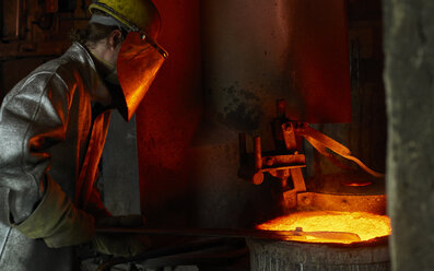 Industrie, Arbeiter am Schmelzofen beim Schmelzen von Kupfer, im Feuerschutzanzug - CVF01208