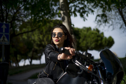 Porträt einer jungen Frau auf einem Motorrad, lizenzfreies Stockfoto