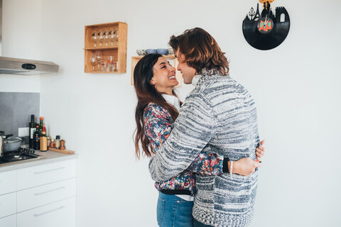 Ehepaar umarmt sich in der Küche, lizenzfreies Stockfoto
