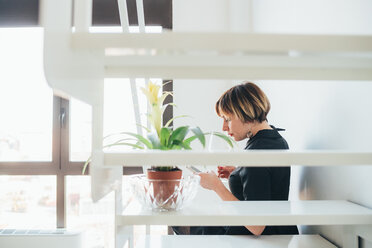 Woman using smartphone on staircase - CUF51292