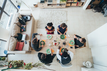 Businessmen and businesswomen celebrating at lunch party in loft office - CUF51301