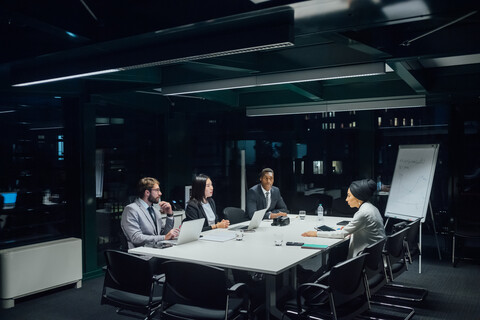 Geschäftsleute und Frauen diskutieren am Konferenztisch, lizenzfreies Stockfoto