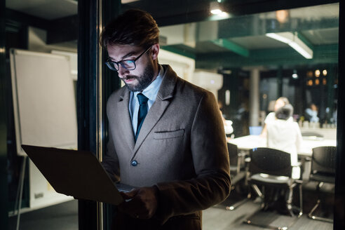 Mid erwachsenen Geschäftsmann suchen Laptop auf Büro Balkon in der Nacht - CUF51344