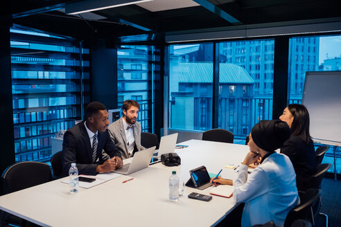 Businessmen and women having discussion over conference table meeting - CUF51345