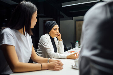 Geschäftsfrauen hören am Konferenztisch zu - CUF51354