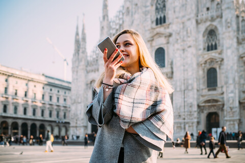 Junge Touristin im Gespräch mit Smartphone am Mailänder Dom, Mailand, Italien, lizenzfreies Stockfoto