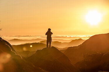 Hiker enjoying view on hilltop at sunset, Preikestolen (Pulpit Rock), Lysefjord, Norway, Stavanger - CUF51392