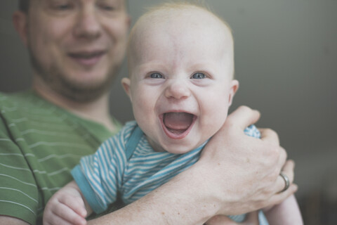 Father holding his laughing baby daughter stock photo