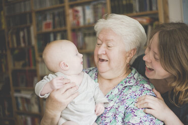 Glückliche Großmutter mit Mutter, die ein kleines Mädchen hält - IHF00004